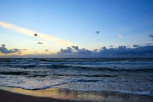 Sunset sky over sea or ocean with sand beach photo