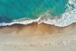 Coastline with blue sea waves and sand beach, top view photo