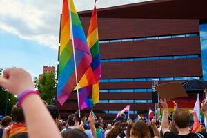 People crowd with LGBTQ rainbow flags on pride demonstration photo