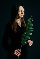 Woman portrait with palm leaf in hand photo