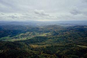 Frone flight over mountain landscape with autumn forest. Mountain village photo