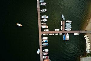 Aerial top view of boats near wooden pier at lake photo