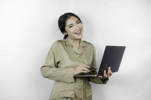 Happy government worker woman holding her laptop while smiling. PNS wearing khaki uniform. photo