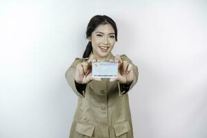 Smiling government worker woman holding Indonesian ID card. PNS wearing khaki uniform. photo