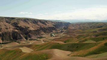 Mountain peaks and grassland are under white clouds. video