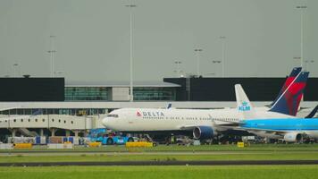 amsterdam, das Niederlande Juli 27, 2017 - - boeing 767 von Delta Fluggesellschaften rollen beim Schiphol Flughafen, Amsterdam. Traktor Abschleppen ein Verkehrsflugzeug. Tourismus und Reise Konzept video