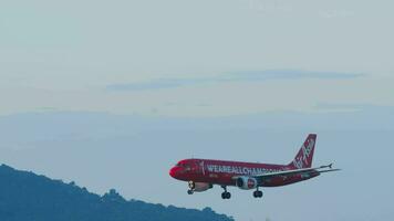 PHUKET, THAILAND DECEMBER 2, 2018 - AirAsia A320 in  We are all champions  special livery landing from the sea at Phuket airport, Thailand video