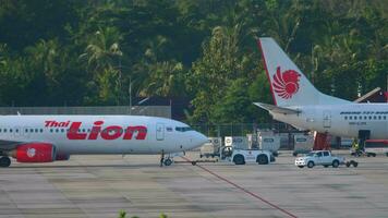 phuket, Thailand november 27, 2019 - Thais leeuw boeing 737 voortvarend terug voordat vertrek, phuket Internationale luchthaven. Thais leeuw lucht passagier Jet laag kosten vliegmaatschappij trekt een trekker naar de terminal video