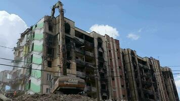 el proceso de desmantelamiento el antiguo edificio. el excavador rompe el casa. demolición de arruinado alojamiento. construcción excavador demuele el casa. Ucrania, Irpin - mayo 12, 2023. video