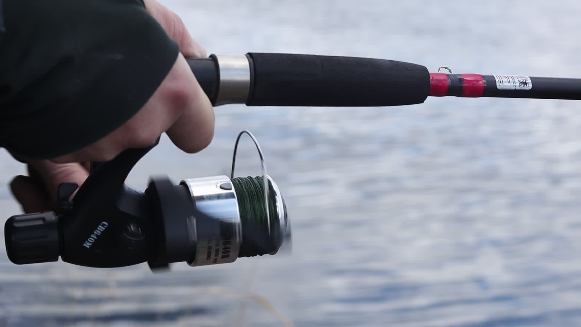 A fisherman spins a reel on a spinning rod. Rotation of the handle with a  fishing rod reel, slow motion. The concept of lifestyle and hobbies in  nature. Ukraine, Kyiv - March