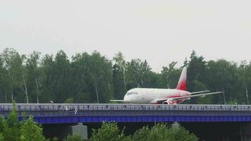 MOSCOW, RUSSIAN FEDERATION JULY 29, 2021 - Sukhoi Superjet of Rossiya taxiing at Sheremetyevskoe highway. Bridge for aircraft from the new runway to the terminal of Sheremetyevo Airport SVO video