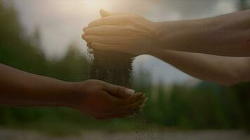 travail en équipe de une homme et une femme goutte le sable dans chaque autres mains en plein air dans la nature video
