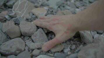 la personne émouvant le sable des pierres avec main en plein air dans la nature video