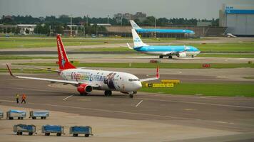 AMSTERDAM, THE NETHERLANDS JULY 30, 2017 - Boeing 737 of Corendon Dutch Airlines VriendenLoterij Livery at Amsterdam airport. Aircraft of KLM Airlines taxiing in the background video