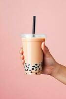 A hand holding takeaway plastic cup of delicious iced bubble milk tea and black pearls. ai generated photo