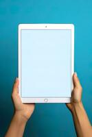 Hand holding tablet with mockup blank screen isolated on blue background. ai generated photo