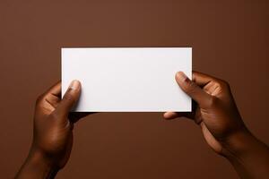 A human hand holding a blank sheet of white paper or card isolated on brown background. ai generated photo