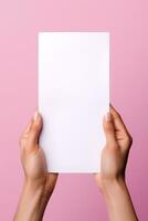 A human hand holding a blank sheet of white paper or card isolated on pink background. ai generated photo