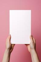 A human hand holding a blank sheet of white paper or card isolated on pink background. ai generated photo