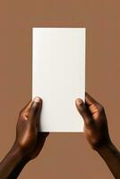 A human hand holding a blank sheet of white paper or card isolated on brown background. ai generated photo