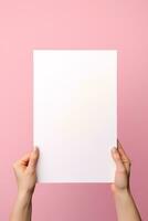 A human hand holding a blank sheet of white paper or card isolated on pink background. ai generated photo