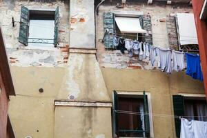 Old grungy building with linen outside photo