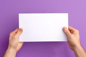 A human hand holding a blank sheet of white paper or card isolated on purple background. ai generated photo