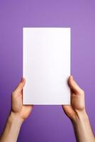 A human hand holding a blank sheet of white paper or card isolated on purple background. ai generated photo