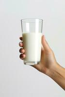 Hand holding a glass of fresh milk isolated on grey background. ai generated photo