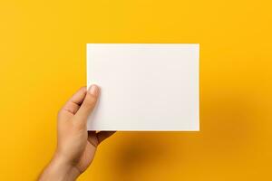 A human hand holding a blank sheet of white paper or card isolated on yellow background. ai generated photo