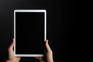 Hand holding tablet with mockup blank screen isolated on black background with copy space. ai generated photo