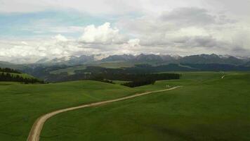 Berg Spitzen und Wiese sind unter Weiß Wolken. video