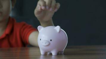 boy put a coin in piggy bank, 4k footage video