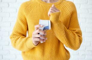 woman in yellow sweater using fabric pills removing tool photo