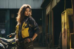Young cool woman wearing motorcycle gear and helmet, AI Generated photo