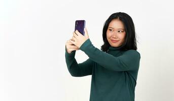 participación teléfono inteligente y tomando selfie de hermosa asiático mujer aislado en blanco antecedentes foto