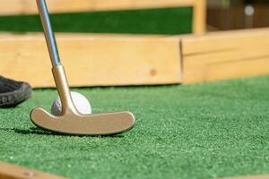 unrecognizable person playing mini golf photo