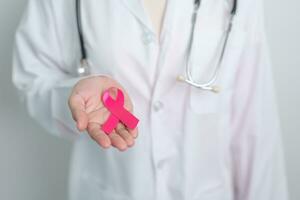 Pink October Breast Cancer Awareness month, doctor with pink Ribbon in hospital for support people life and illness. National cancer survivors month, Mother and World cancer day concept photo