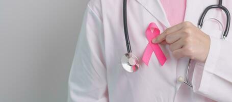 Pink October Breast Cancer Awareness month, doctor with pink Ribbon in hospital for support people life and illness. National cancer survivors month, Mother and World cancer day concept photo