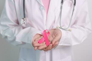 Pink October Breast Cancer Awareness month, doctor with pink Ribbon in hospital for support people life and illness. National cancer survivors month, Mother and World cancer day concept photo