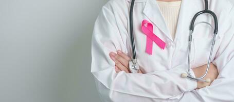 Pink October Breast Cancer Awareness month, doctor with pink Ribbon in hospital for support people life and illness. National cancer survivors month, Mother and World cancer day concept photo