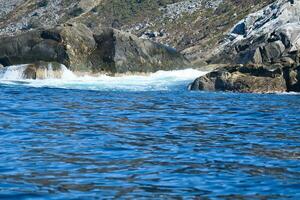 norway on the fjord, spray on rocks. Water splashes on the stones. Coastal landscape photo