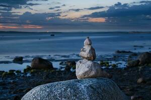 Stone pyramid on the Baltic Sea with a view of the sea at sunset and blue hour photo