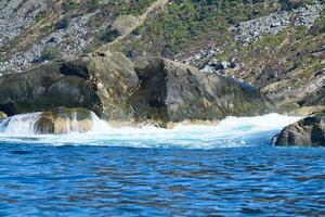norway on the fjord, spray on rocks. Water splashes on the stones. Coastal landscape photo