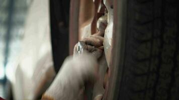 asiatique homme voiture mécanicien remplacer une voiture pneu dans garage atelier. . auto service, entretien de la voiture centre supprime le roue, réparation et entretien de le voiture dans service. video