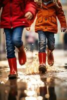 Children wearing red rubber boots walk through a puddle while using technology photo
