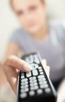 Young woman with remote watching TV. photo