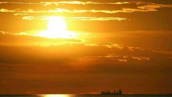 le coucher du soleil retour sur le foncé nuage sur le océan et silhouette cargaison navire sur le horizon video