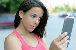 Girl using tablet PC outdoor photo