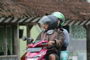 magelang, indonesia, 2023-a mujer y un hombre en su camino a través de el la carretera. foto